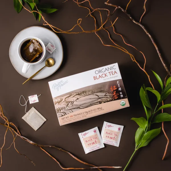 Image of the box and a cup of Prince of Peace Organic Black tea with aesthetic background