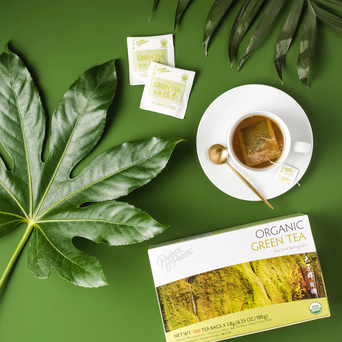 Image of the box and a cup of Prince of Peace Organic Green tea in aesthetic background