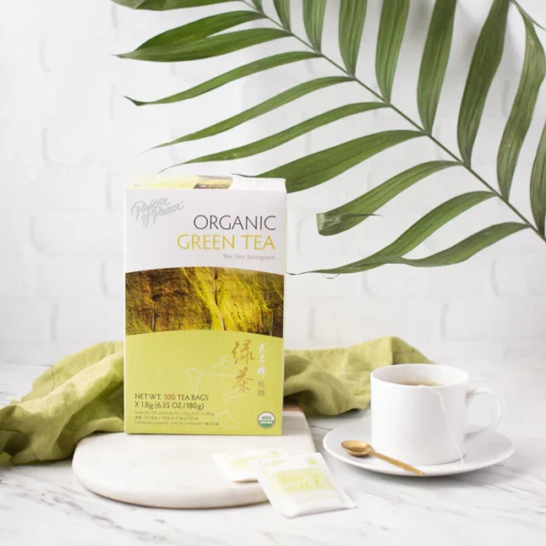 Image of the box and a cup of Prince of Peace Organic Green tea in aesthetic background