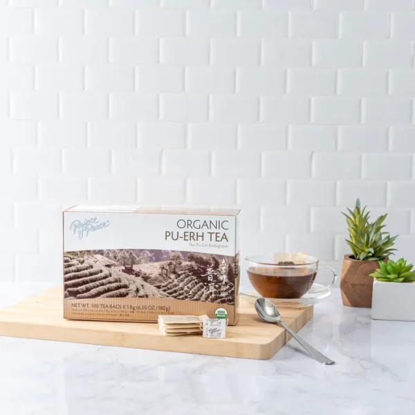 image of box and a brewed cup of Prince of Peace Pu-Erh tea with aesthetic background